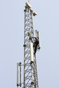 Cell tower technician climbing tower